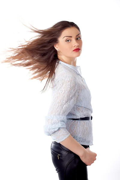 Ung flicka isolerad på vit med vinden i håret i studio — Stockfoto