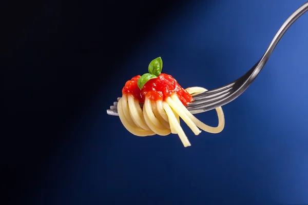 Espaguete com molho de tomate embrulhado em um garfo — Fotografia de Stock