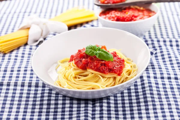 Spaghetti con sugo di pomodoro sul classico tavolo di casa — Foto Stock