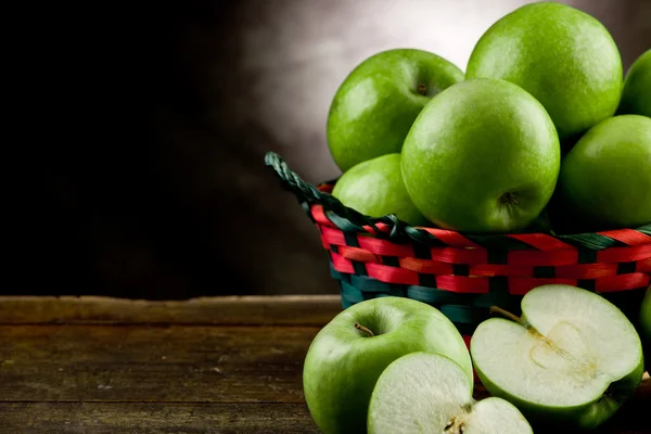 Gröna äpplen i en korg — Stockfoto