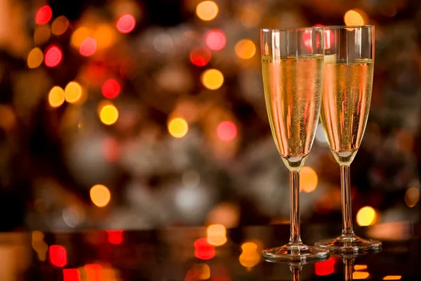 Champagner op glazen tafel met bokeh achtergrond Stockfoto
