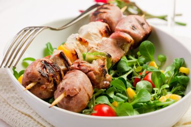 Meat Skewers on white table clipart