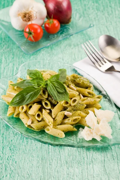 Pasta met pesto op groen glazen tafel — Stockfoto