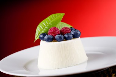 Panna cotta kırmızı zemin üzerine çilek ile