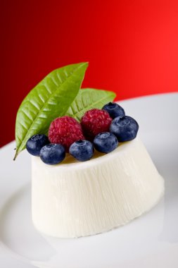 Panna cotta kırmızı zemin üzerine çilek ile