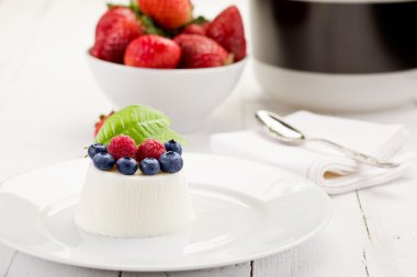 Panna cotta beyaz masa üzerinde çilek ile