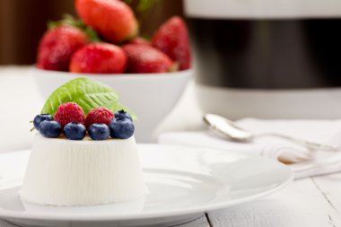 Panna cotta beyaz masa üzerinde çilek ile