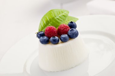 Panna cotta beyaz masa üzerinde çilek ile