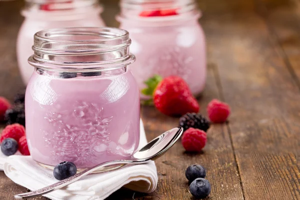 Маленькие банки с домашним йогуртом и ягодами — стоковое фото