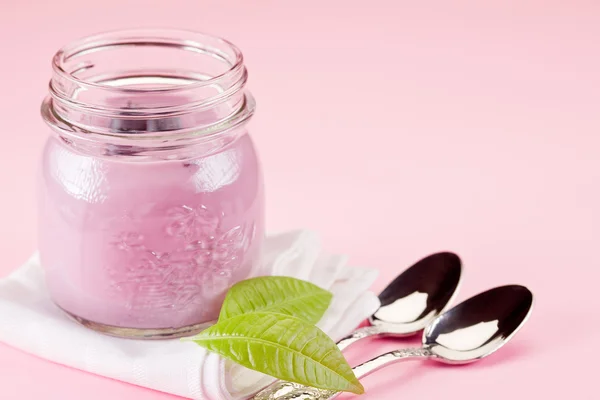 Yoghurt op rose achtergrond — Stockfoto