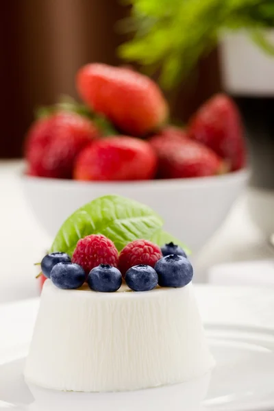 Панна Котта с ягодами на белом столе — стоковое фото