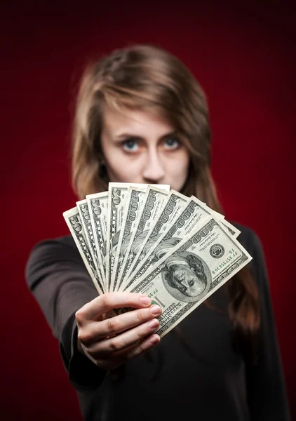 Mladá žena ukazující fanoušek dolarů — Stock fotografie