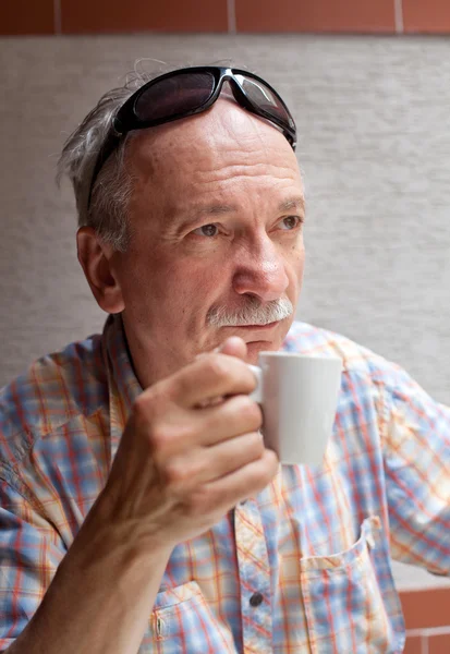 Old man drinking cup of coffee — Stok fotoğraf