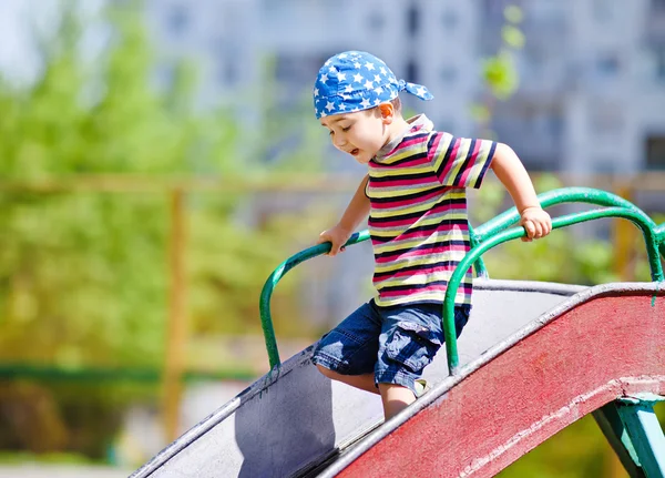 Мальчик играет на слайде — стоковое фото