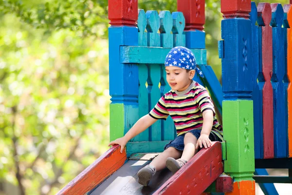 Chłopiec grający na slajdzie — Zdjęcie stockowe