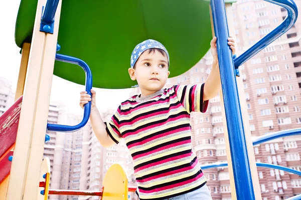 Młody chłopak w chustka na plac zabaw dla dzieci — Zdjęcie stockowe
