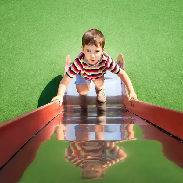 Хлопчик піднімається на слайд — стокове фото
