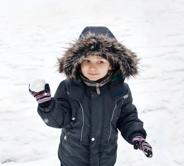 Lindo chico sosteniendo bola de nieve —  Fotos de Stock