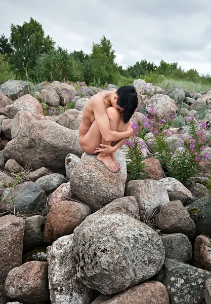 Nude woman sitting on stones — Stock Photo, Image