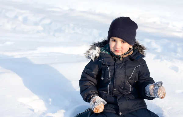 Lycklig pojke som leker i snö — Stockfoto