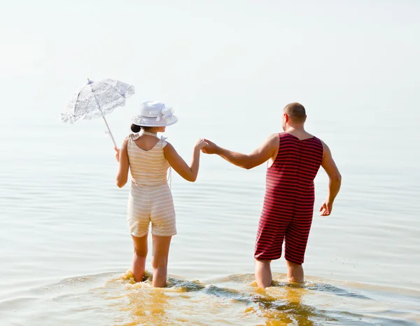 Мужчина и женщина в винтажных полосатых купальниках — стоковое фото