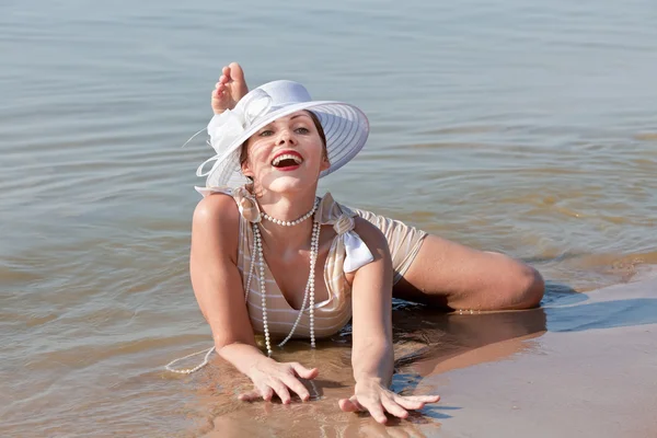 Mulher de chapéu branco posando contra o mar — Fotografia de Stock