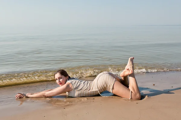 Donna sdraiata in acqua sulla spiaggia — Foto Stock