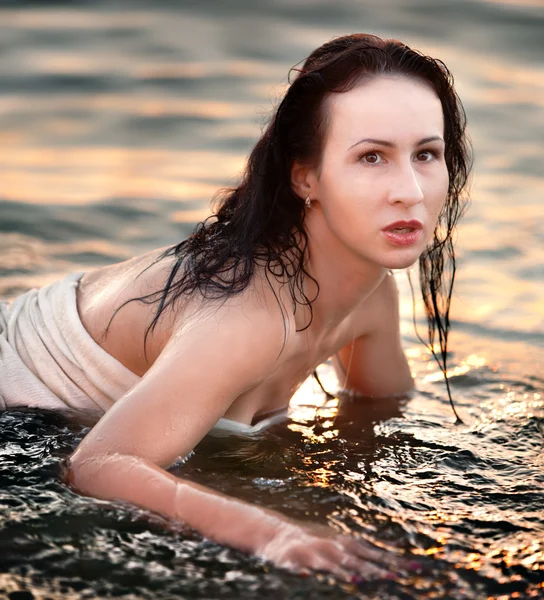 Giovane ragazza sdraiata nel mare — Foto Stock