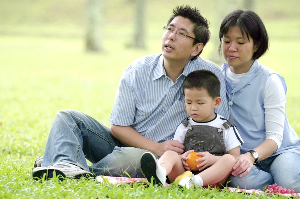 Asiatiska familj har picknick under utomhus, fokus på barnet — Stockfoto