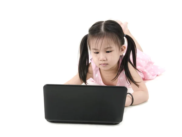 Belle petite fille assise sur le sol à l'aide d'un ordinateur portable, bac blanc — Photo
