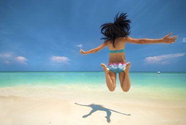 Bikini genç kız plajda havada yukarı atlıyor
