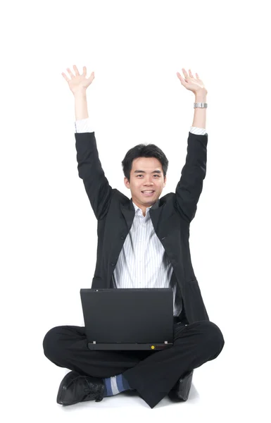 Feliz joven asiático hombre de negocios sentado con un ordenador portátil y rasing h —  Fotos de Stock