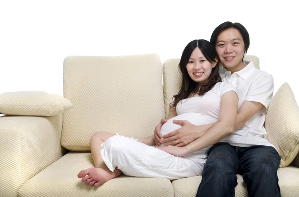 Asiatisches Paar. Mann und im achten Monat schwangere Frau sitzen auf Sofa — Stockfoto