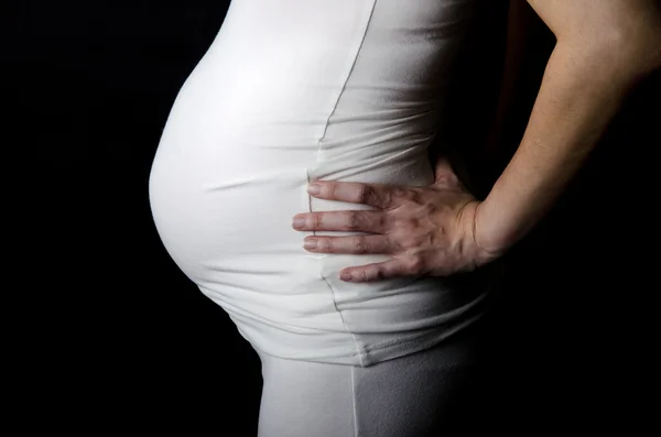 Těhotenství žena na černém pozadí — Stock fotografie