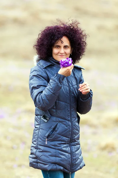 Gekrulde redhead vrouw crocus bloemen plukken — Stockfoto