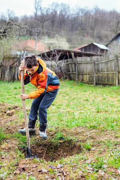 Pojken gräva i marken — Stockfoto