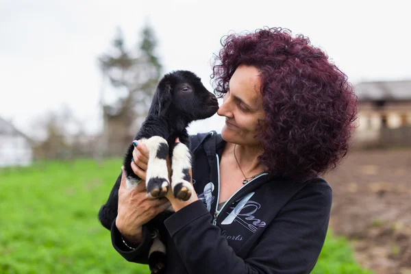 Vrouw met een baby geit — Stockfoto