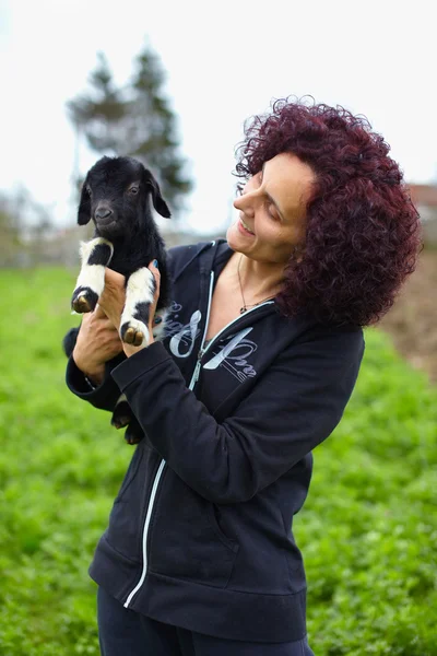 Женщина держит маленького козла — стоковое фото