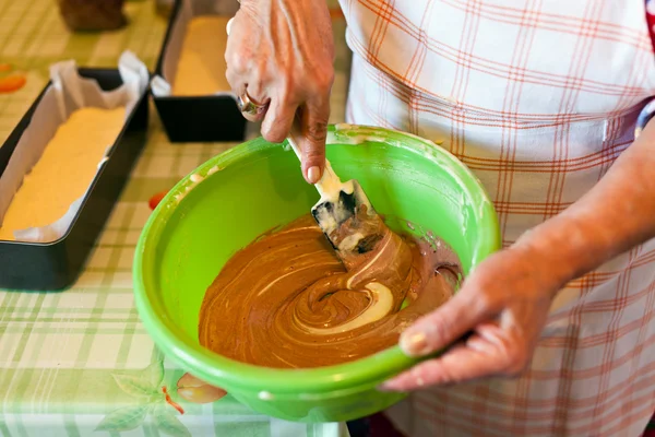 Starší ženské ruce míchání kakaový krém s špachtlí — Stock fotografie