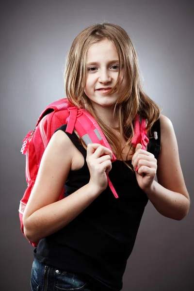 Blond skolflickas med ryggsäck i studio — Stockfoto