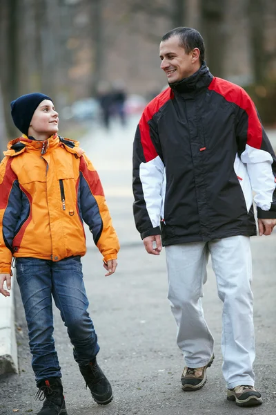 Отец и сын гуляют по парку — стоковое фото