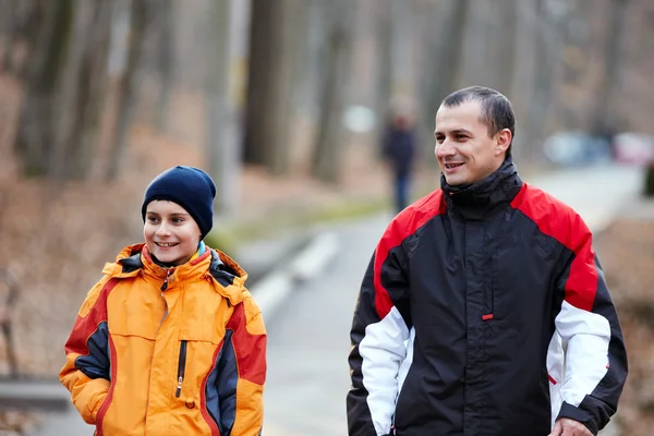 Отец и сын гуляют по парку — стоковое фото