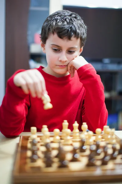 Мальчик играет в шахматы, избирательный фокус — стоковое фото