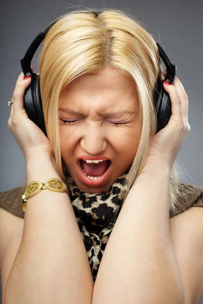 Jovem senhora gritando ou cantando na música nos fones de ouvido — Fotografia de Stock