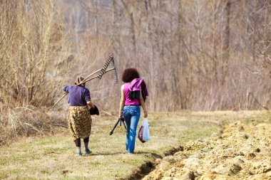 Women returning home from working at field clipart