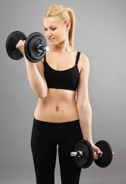 Atletica giovane donna che lavora con i pesi — Foto Stock
