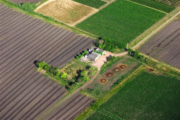 Vista aérea de uma casa de campo com campos verdes — Fotografia de Stock