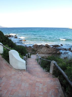 merdiven ve dalgalar ile kayalık plaj