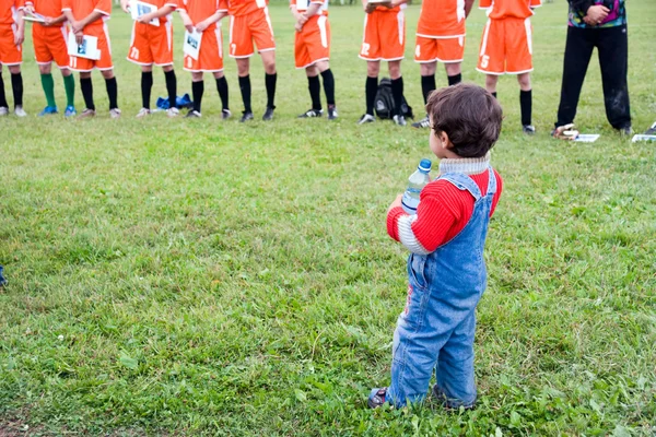 Jongen kijkt op soccers — Stockfoto