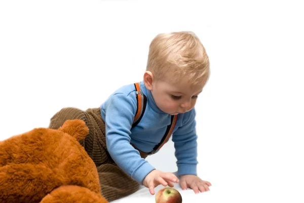Bebê loiro com brinquedo e com maçã — Fotografia de Stock